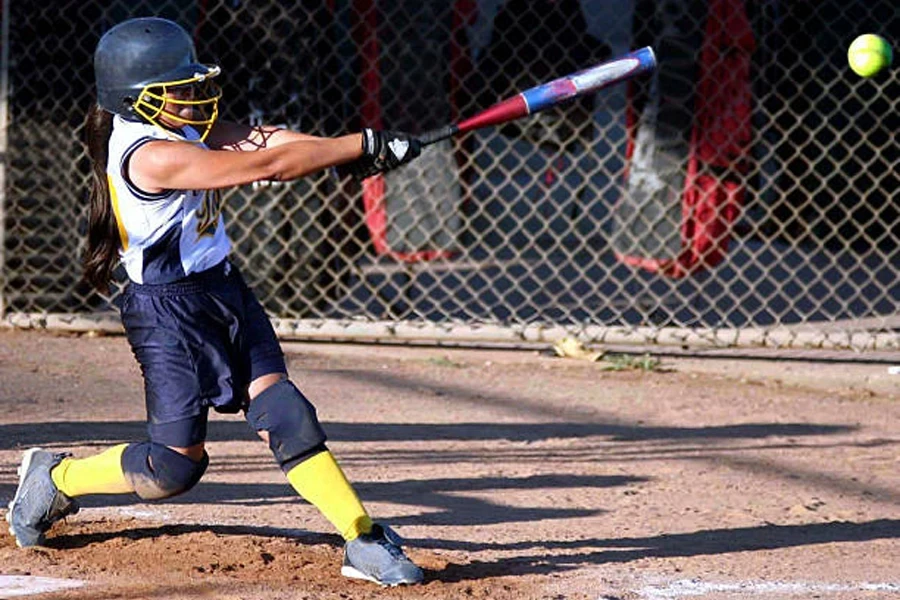 Player wearing softball clothing while hitting a ball with bat