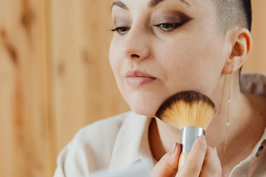 Pretty lady applying concealer with a fan brush