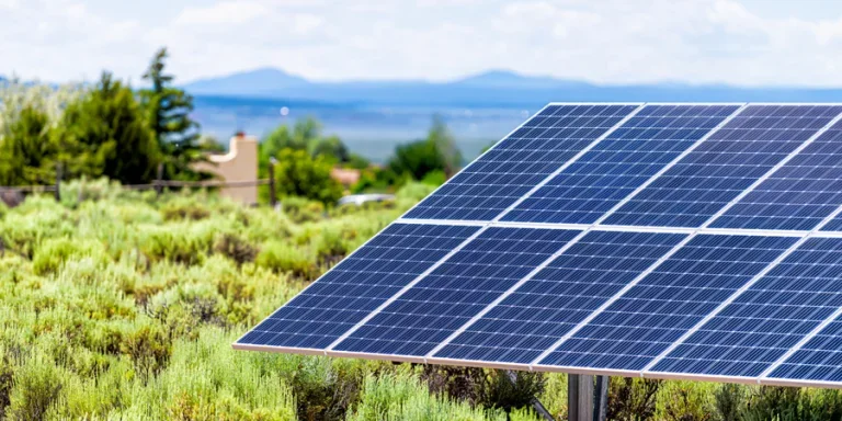 Ranchos de Taos valley green landscape shrubs in summer and closeup of solar panel