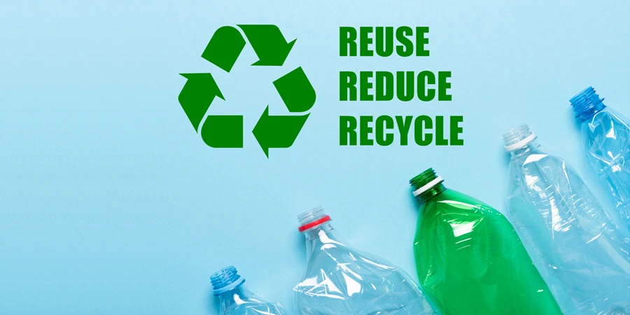 Recycling symbol with reuse reduce recycle text and plastic bottles on blue background top view