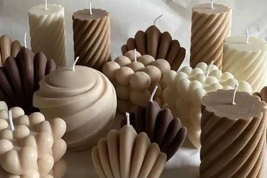 Selection of candles in different shapes, textures, and neutral colors