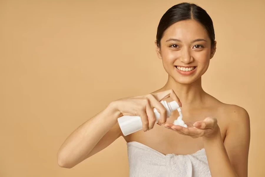 Smiling lady pouring facial cleanser into her palm