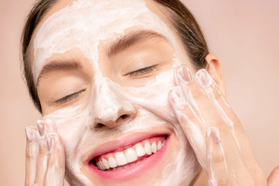 Smiling lady using cleansing foam