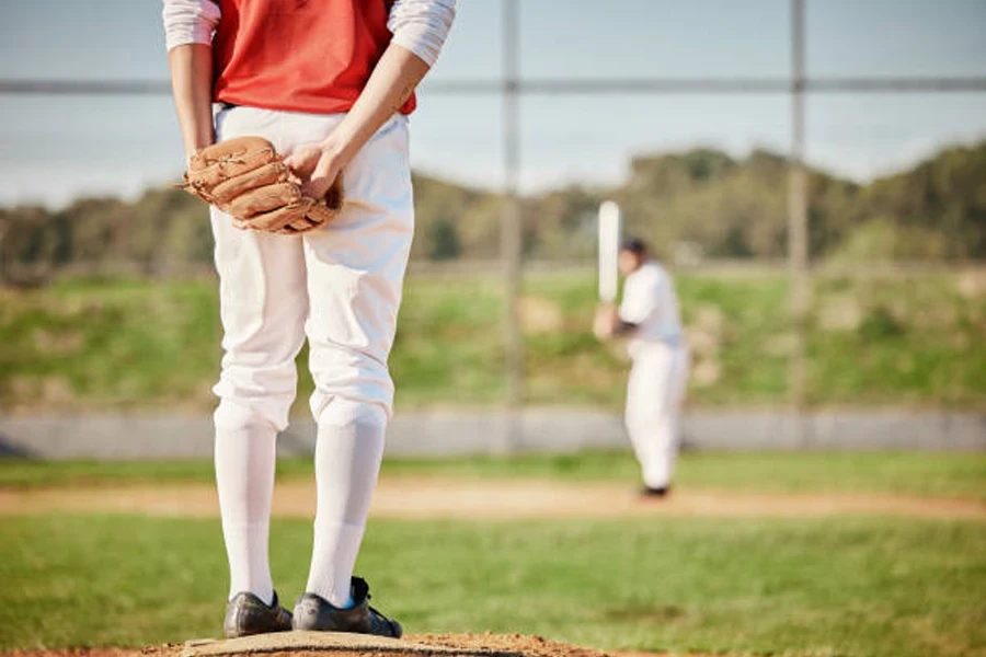 Softball player wearing white softball pants ready to pitch