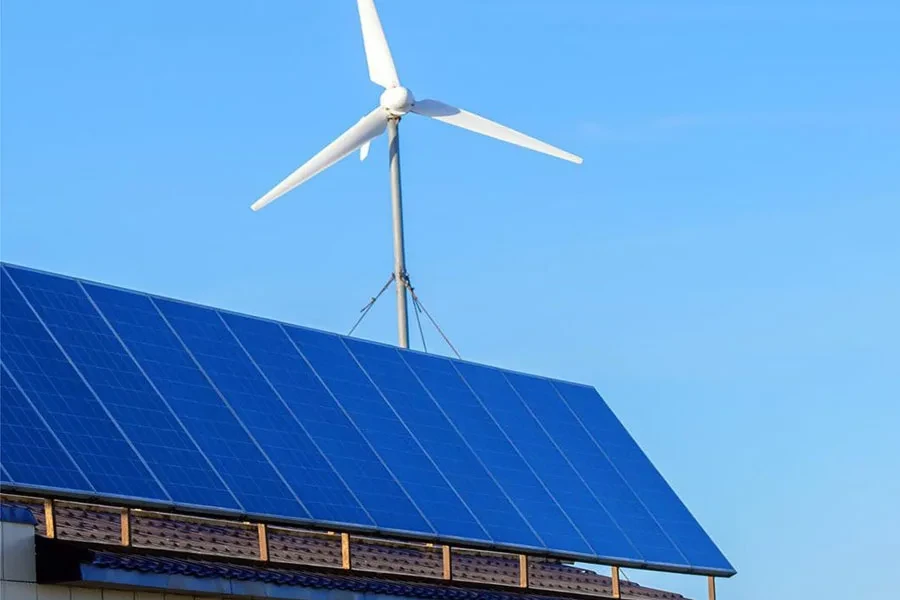 Solar panels and wind turbine on top of a roof