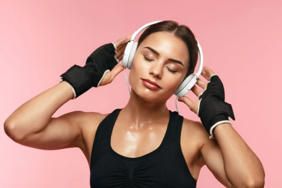 Mujer deportiva escuchando música en auriculares en entrenamiento, disfrutando de la canción en auriculares