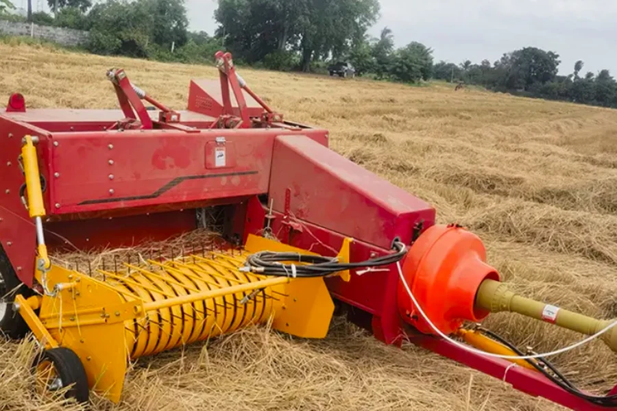 Square hay baler at work in a field