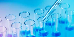 Test tubes with blue liquid water samples and pipette over blue background