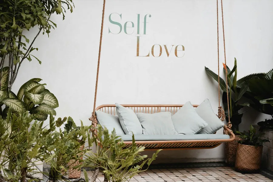 Die Worte „Selbstliebe“ stehen hinter einer Schaukel auf der Terrasse