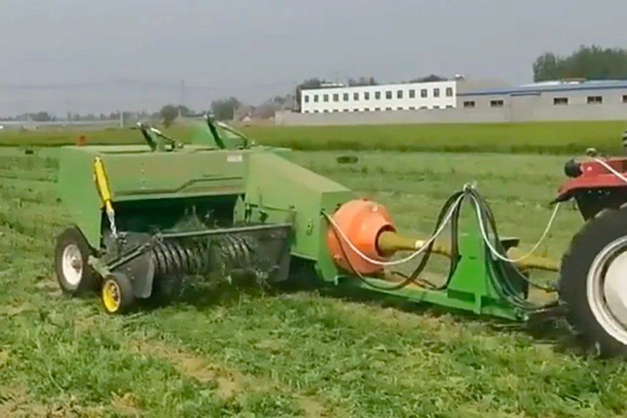 Трактор тянет пресс-подборщик для квадратного сена