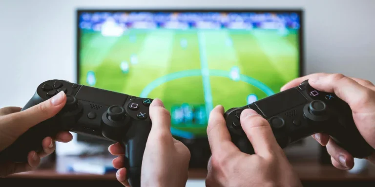 Two People holding Black Gaming Consoles