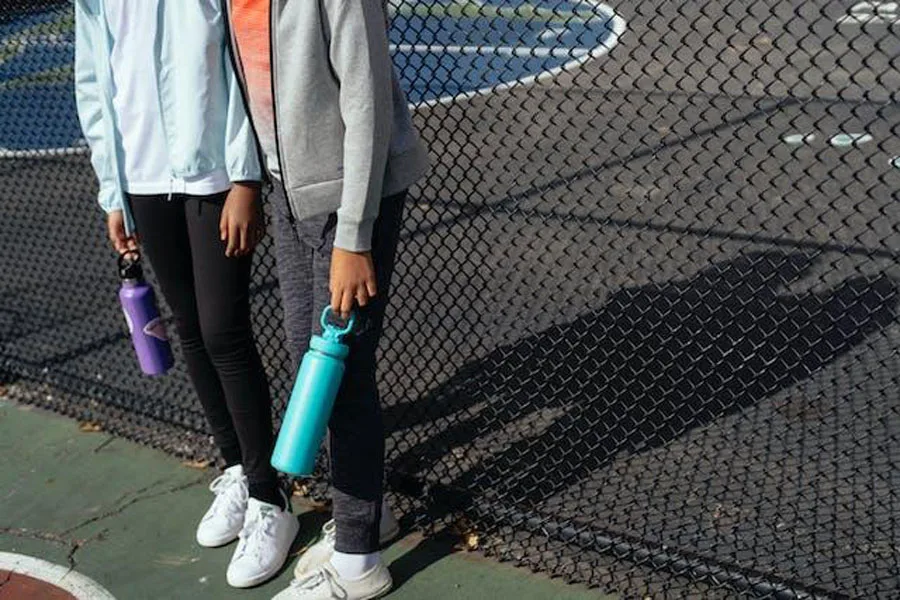 Two girls holding plastic water bottles