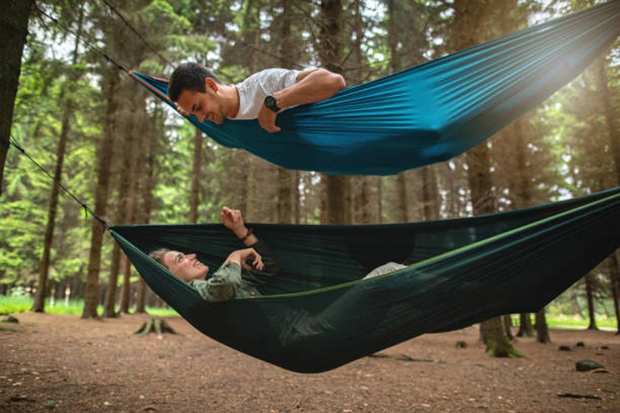 Two hammocks positioned on top of each other in forest
