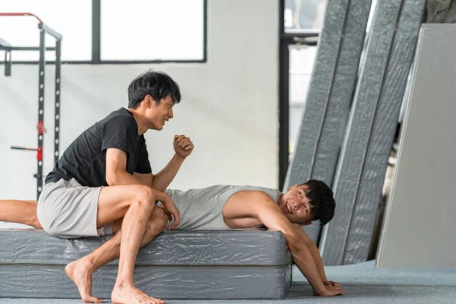 Two men using crash may in a gymnastics gym