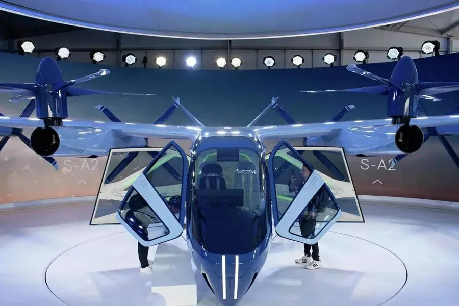 Two people looking inside the Hyundai flying taxi