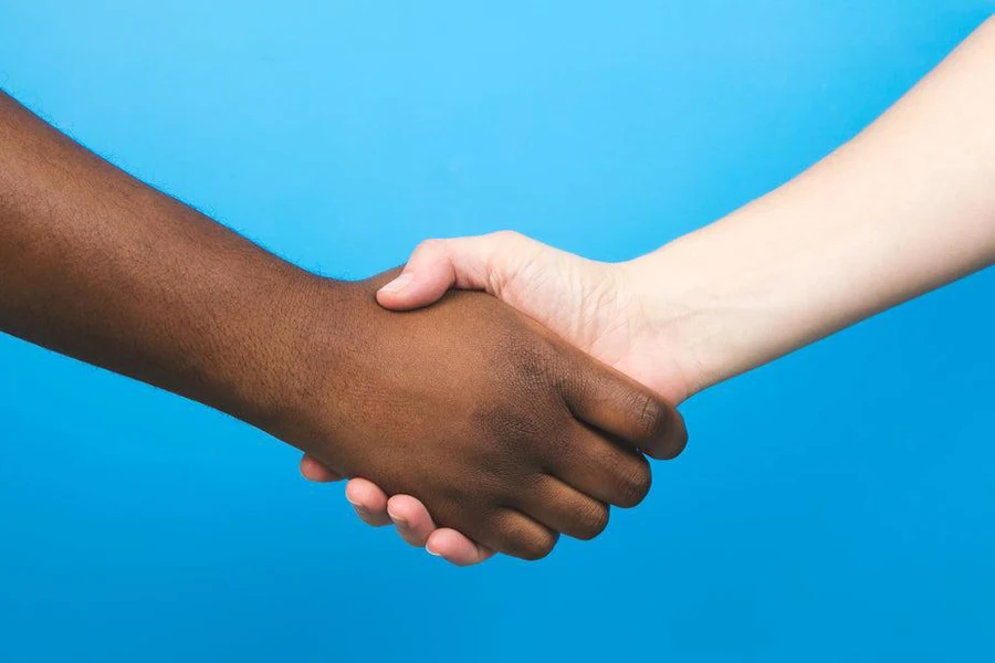 Two people shaking hands against a blue background