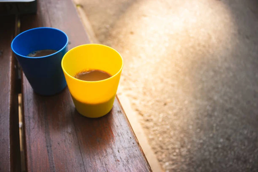 Две пластиковые походные чашки на деревянной скамейке