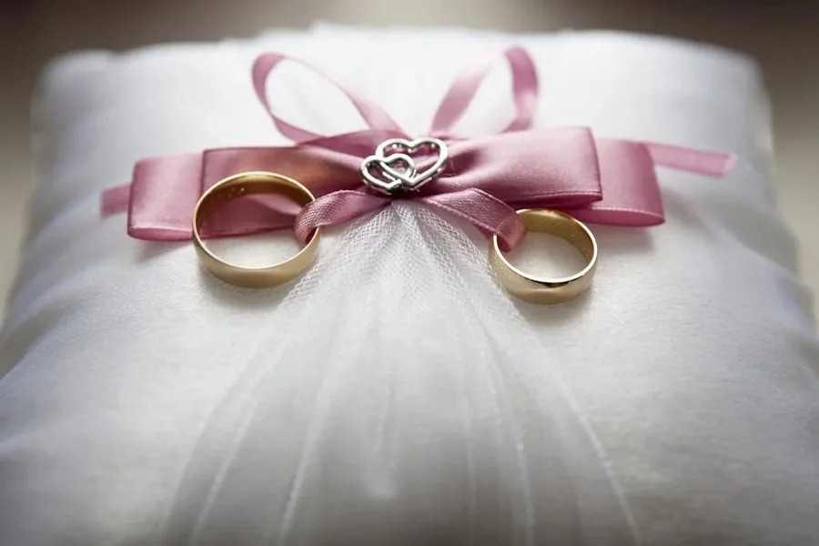 Two wedding or engagement rings tied together