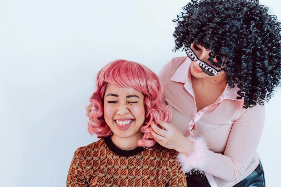 Two women wearing curly wigs