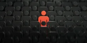 Unique red human figure standing out among darker ones