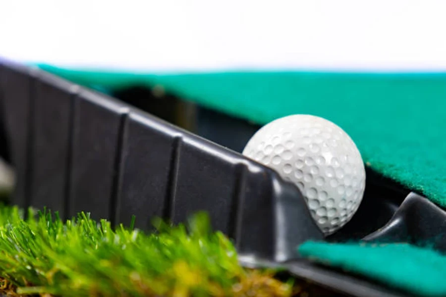 Pelota de golf blanca en sistema de retorno de tapete de golf.