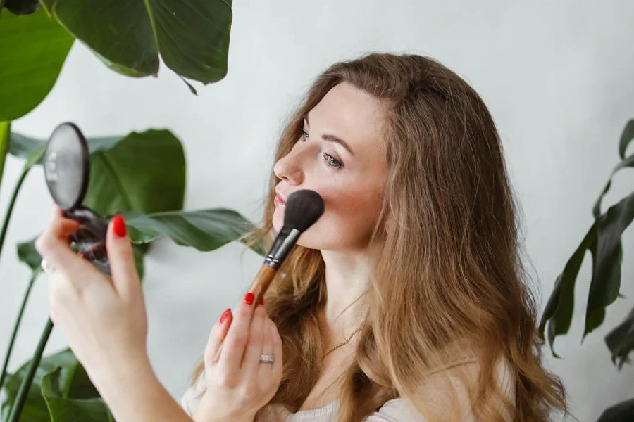 Woman applying makeup while looking in a mirror