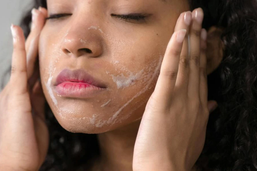 Mulher limpando o rosto com um limpador facial