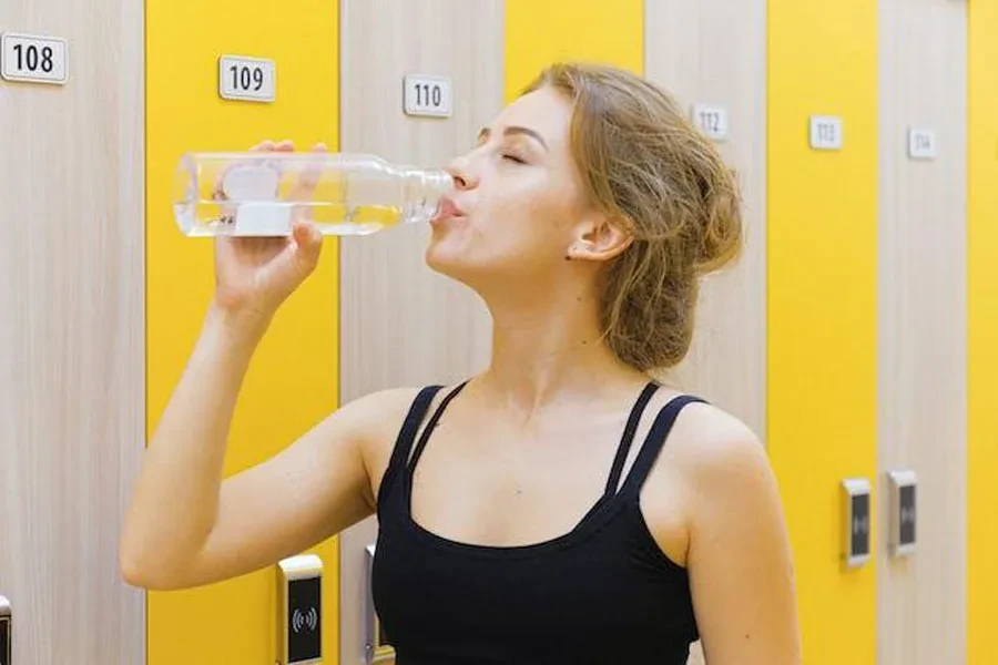 再利用可能な水筒から飲む女性