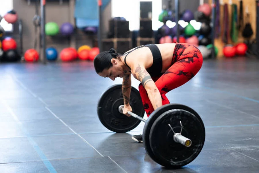 Woman getting ready to lift loaded bar in gym