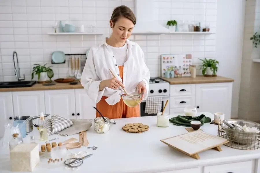 Cam karıştırma kabı ve tahta spatula tutan kadın