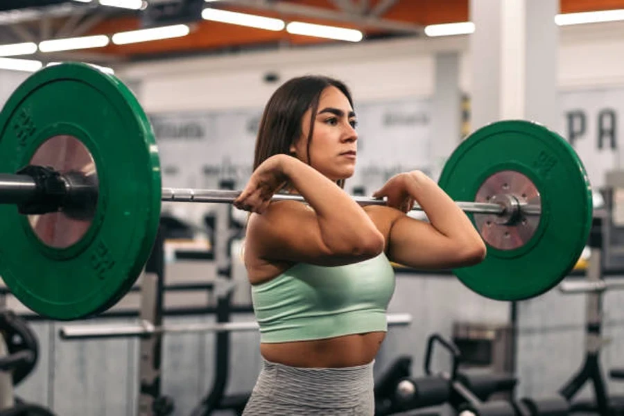 Woman holding bar with barbell collars on the end