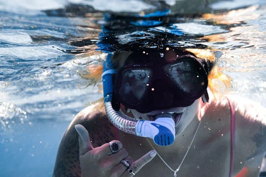 Mujer posando con un snorkel en la boca