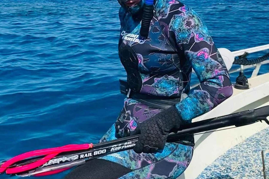 Mulher se preparando para mergulhar em roupa de mergulho de caça submarina