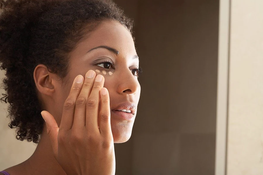 Woman ready to use drops of primer under her eyes
