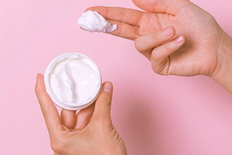 Femme ramassant des crèmes nettoyantes pour le visage