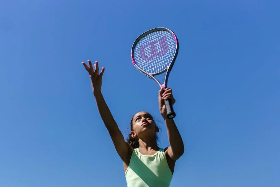 Donna che serve con una racchetta da tennis