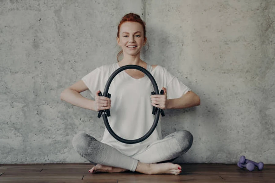 Femme serrant un cercle de yoga noir entre ses mains