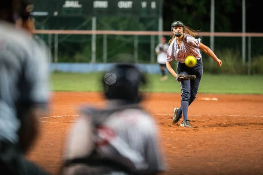 Woman throwing underarm pitch in softball game