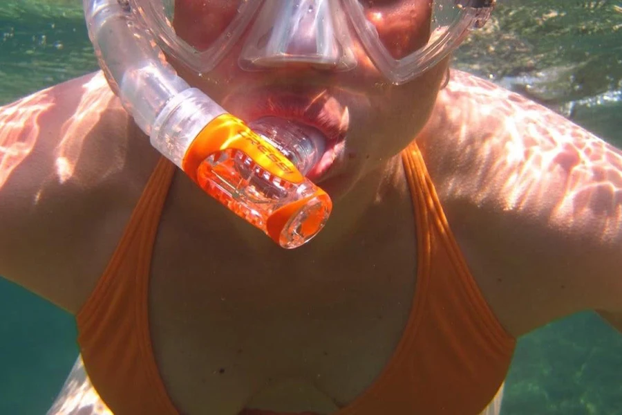Donna che usa un boccaglio per respirare sott'acqua