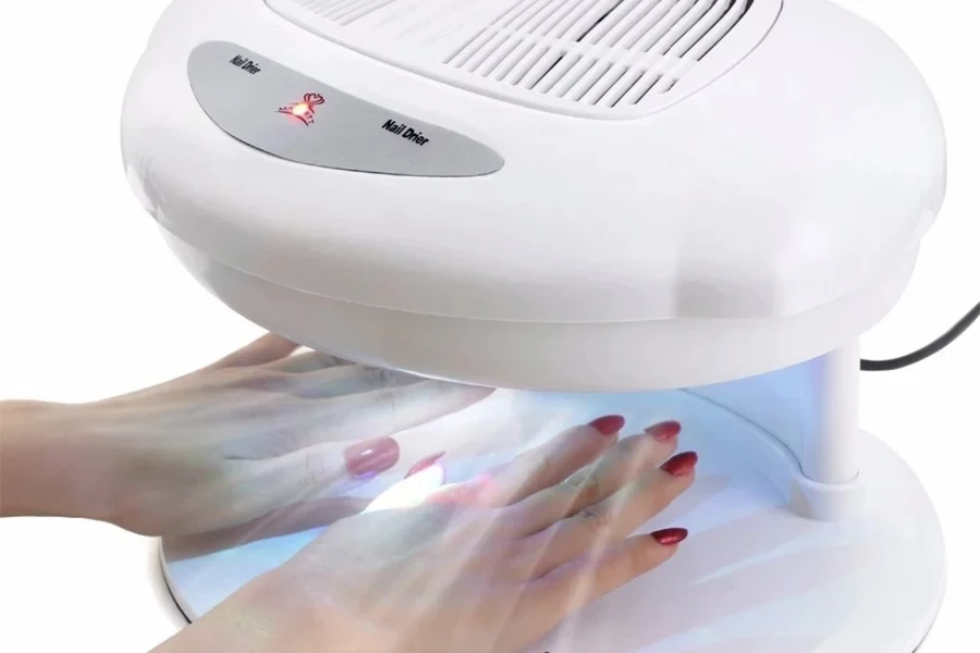 Woman using a white fan nail dryer