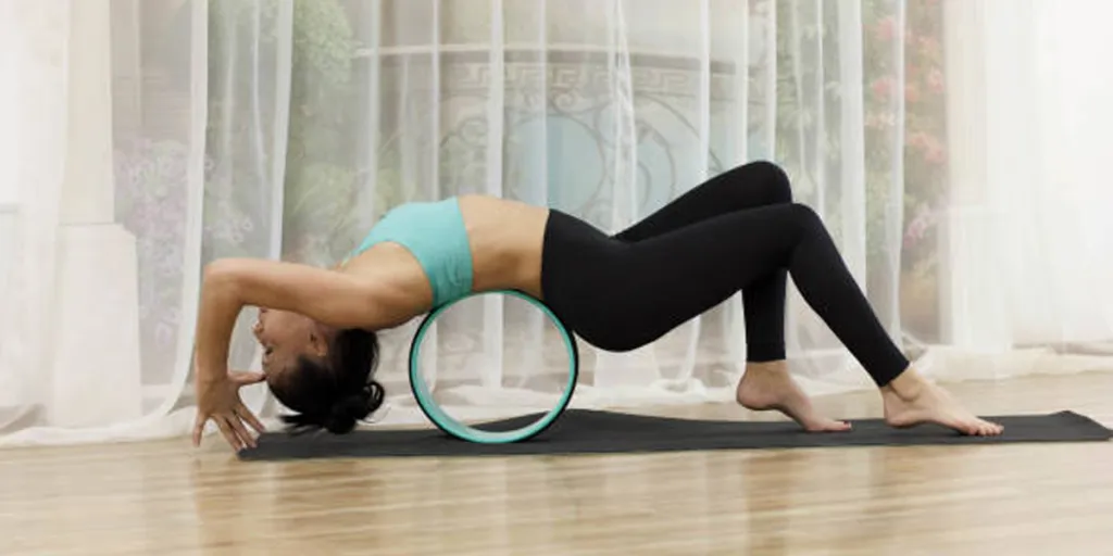 Wanita menggunakan lingkaran yoga biru untuk melakukan latihan