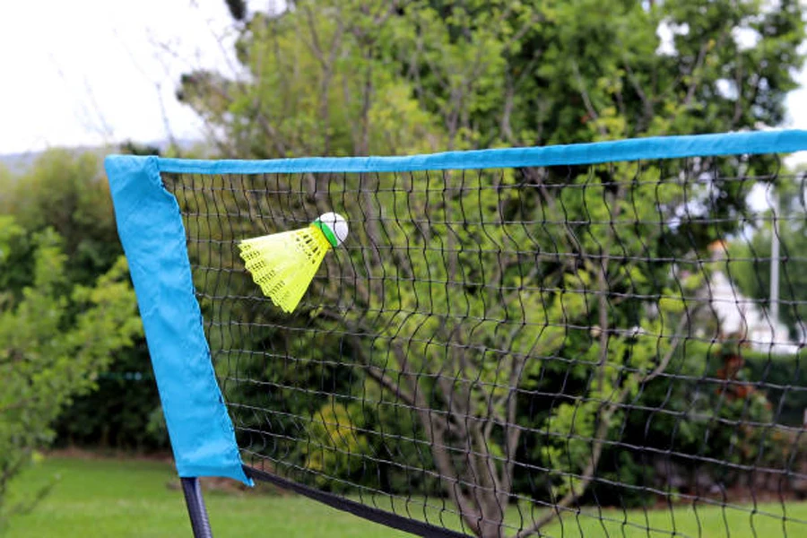Yellow shuttlecock stuck in an outdoor badminton net