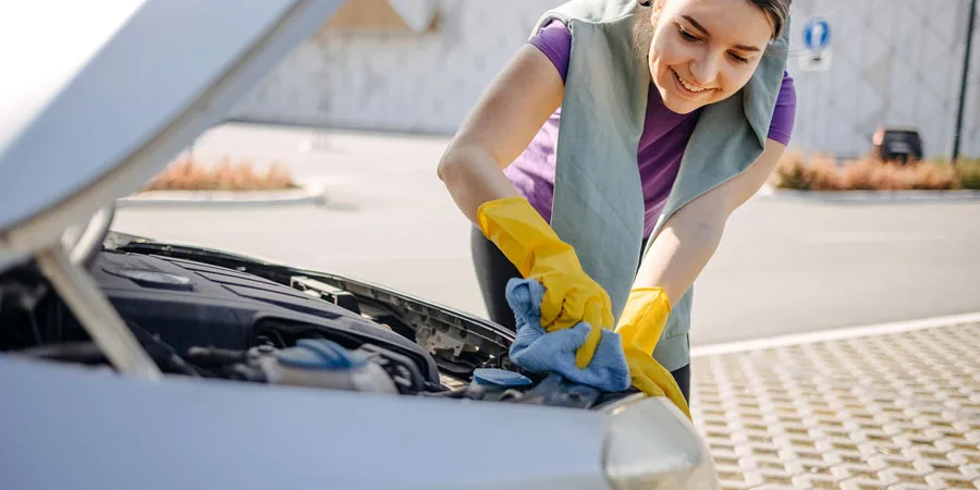 Young woman cleaning car