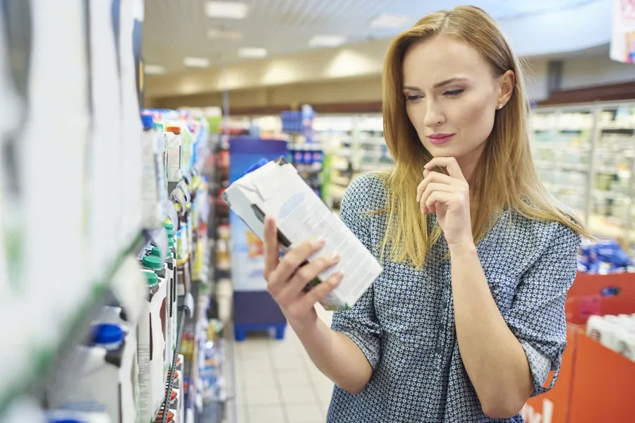 Young woman reading a milk label