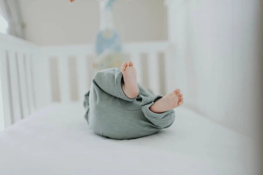 a baby in a crib wearing a sleeper