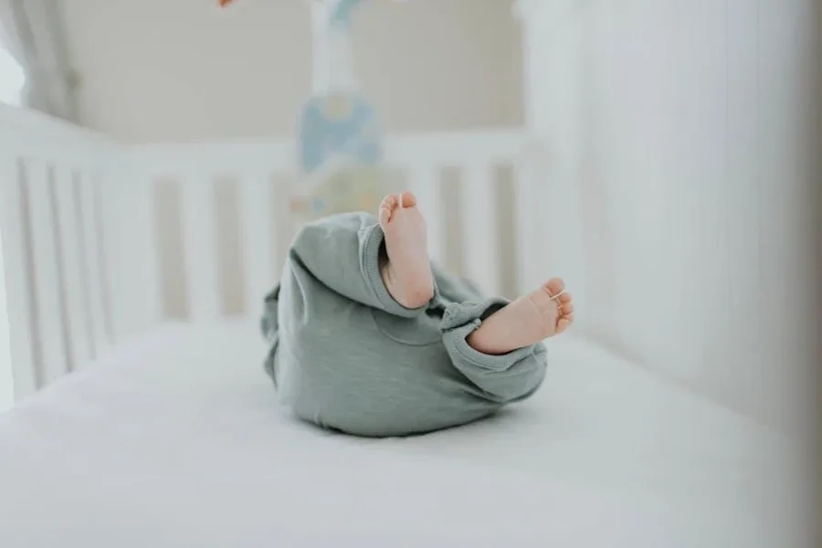 a baby in a crib wearing a sleeper