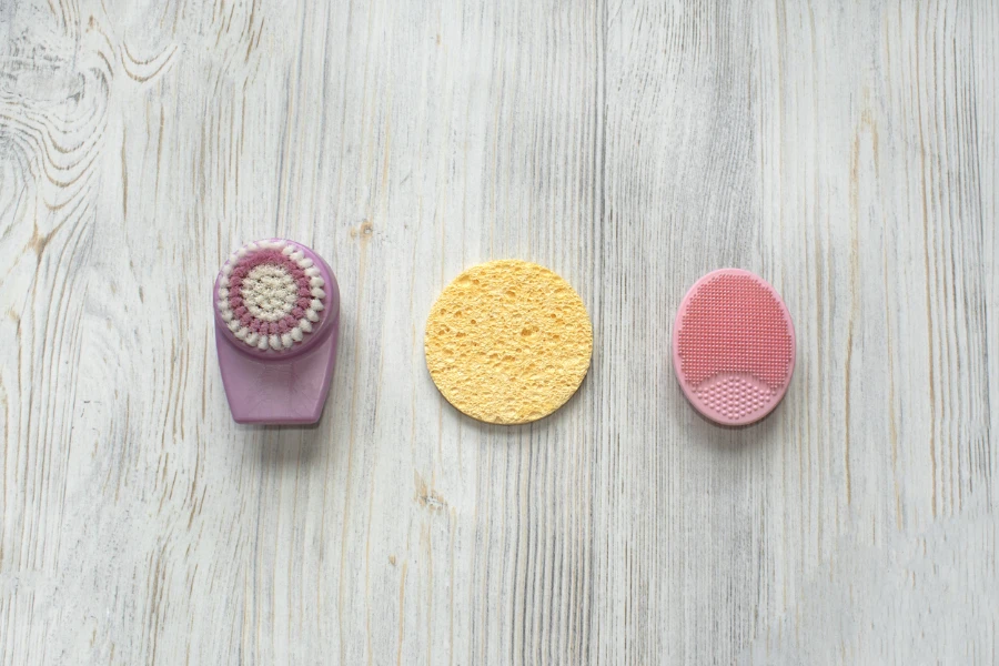 A brush and sponge next to a silicone body scrubber