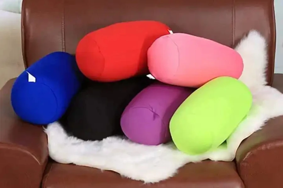 A collection of brightly-colored cylindrical microbead pillows on chair