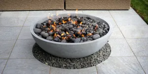 A fire pit on a patio with a couch