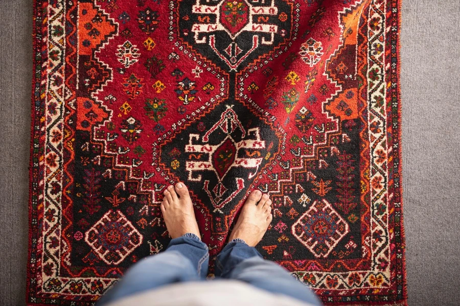 A person standing on a colorful patterned rug